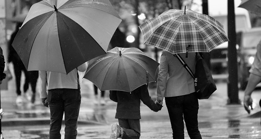 Coppia con bambino sotto la pioggia